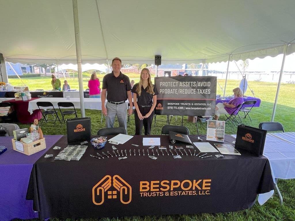 Branded trade-show booth with a custom tablecloth, table tent, and giveaways at a Bespoke Trusts and Estates event.